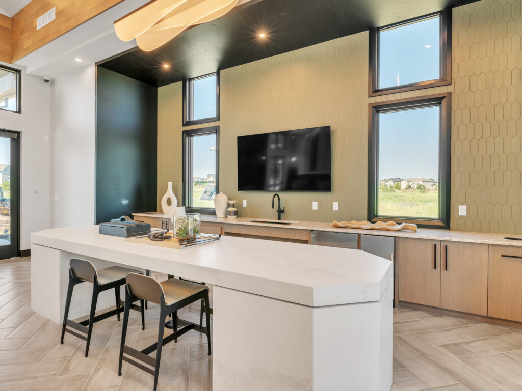 Modern kitchen with a large island, two stools, and light fixtures.