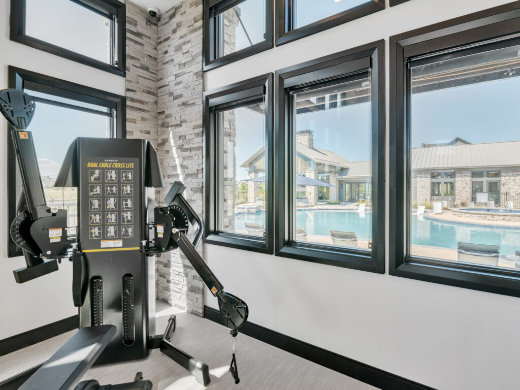 Fitness machine near large windows overlooking a pool area